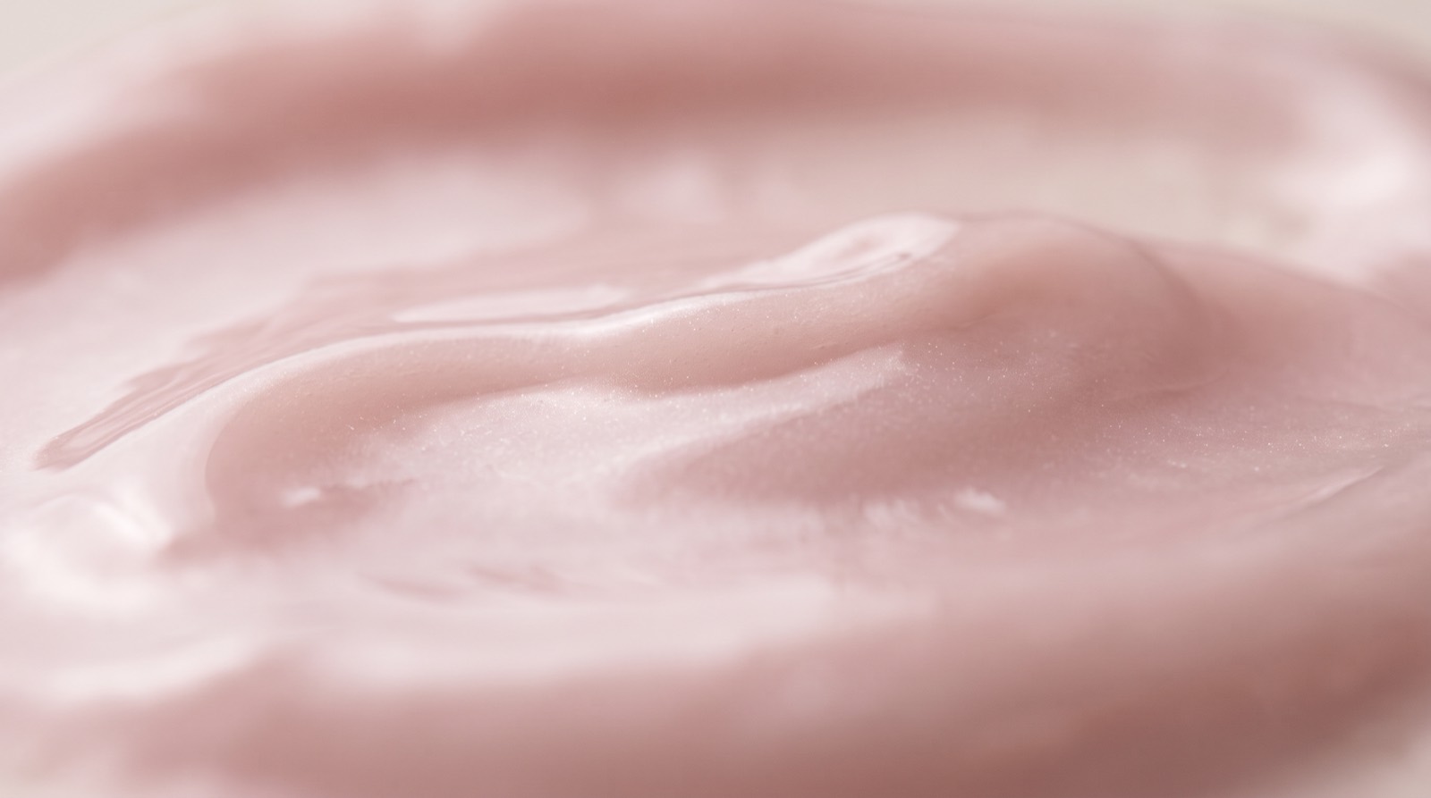 Makroaufnahme einer kühlen, milchig-rosé schimmernden Gel-Textur